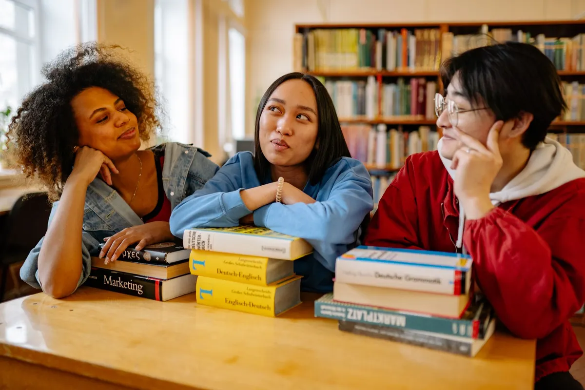 Students discussing their work together in a library